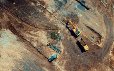 Aerial view of a construction site featuring heavy machinery and trucks, displaying industrial activity.
